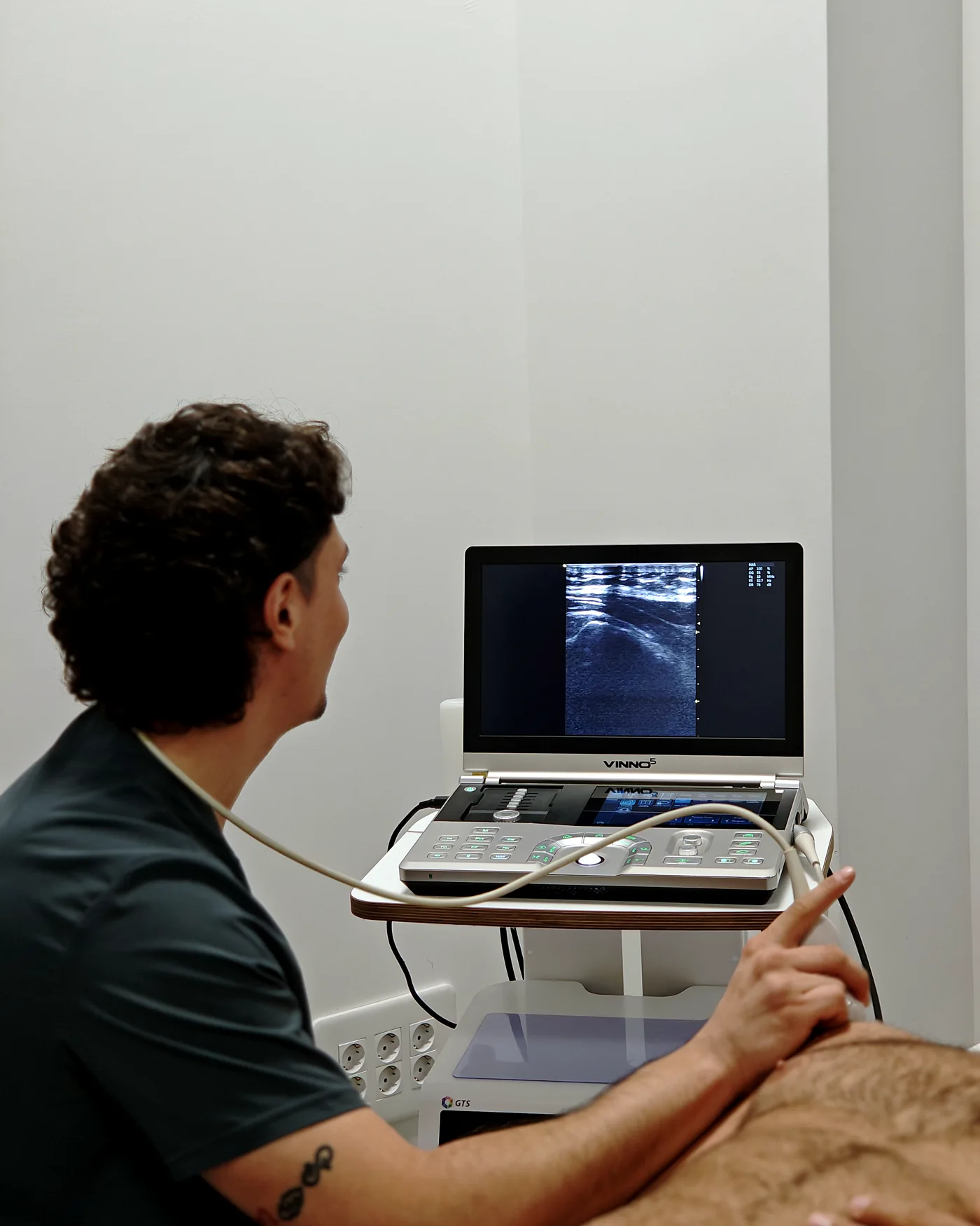 Ecografía musculoesquelética en la primera visita en ADH Clinic, con la imagen en la pantalla del ecógrafo